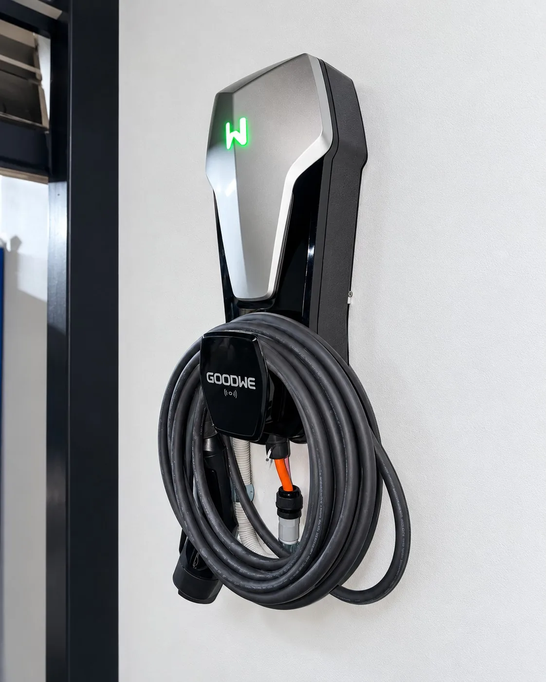 Wall-mounted GoodWe EV charger with the charging cable coiled on its holster