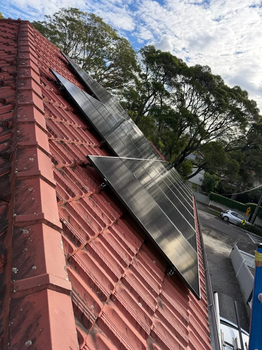 Rows of black solar panels on a terracotta tiled roof