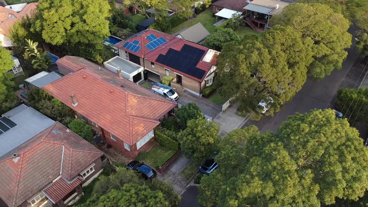 Drone view of a federation home with a large solar array among neighbouring houses